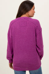 woman wearing a long sleeve purple maternity sweater with a relaxed fit and drop shoulders, showing the back view