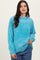 woman wearing a light blue oversized knit sweater with a round neckline and long sleeves