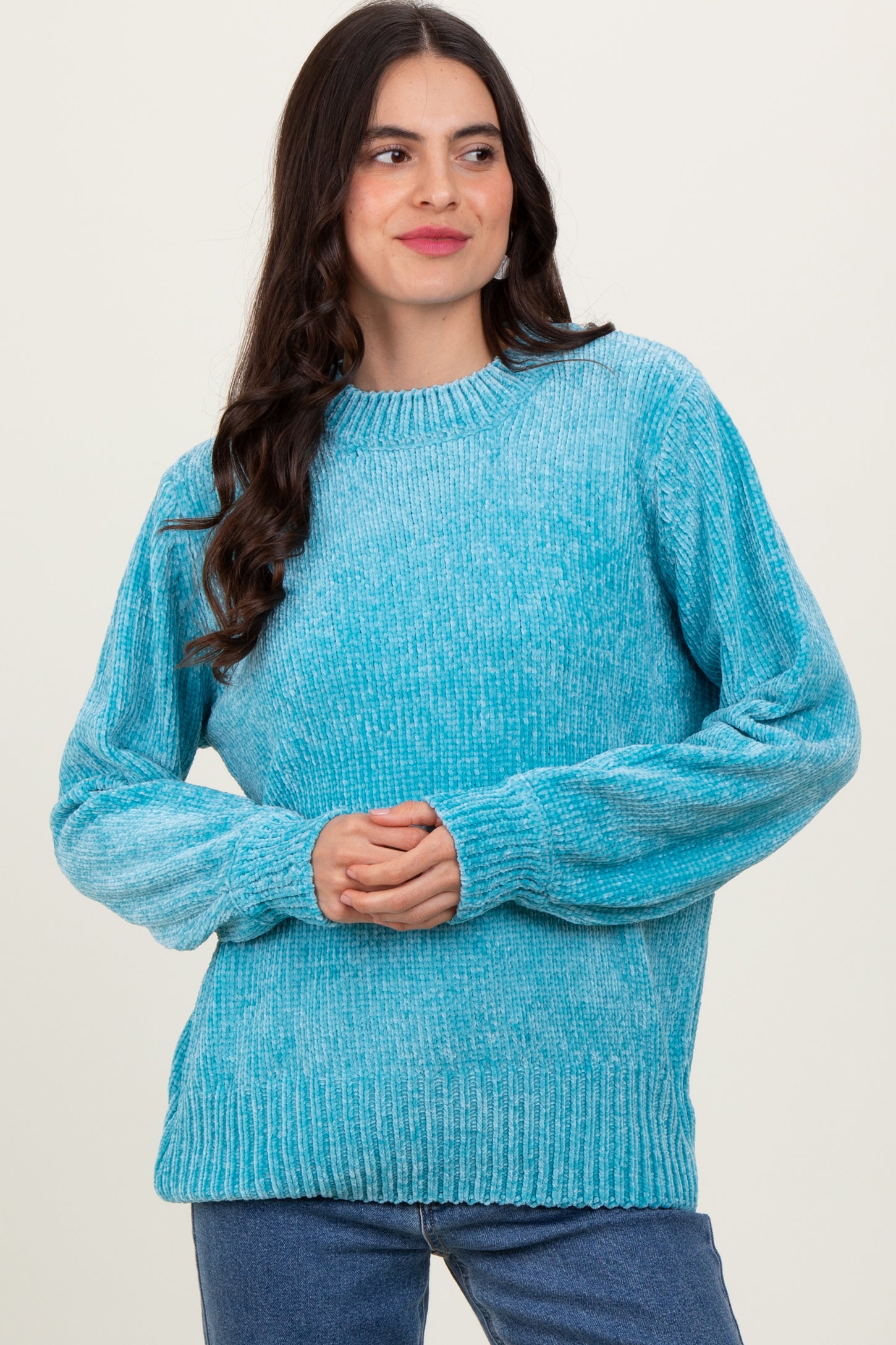 woman wearing a textured light blue long sleeve sweater with a relaxed fit and ribbed hem
