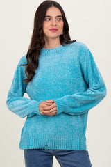 woman wearing a textured light blue long sleeve sweater with a relaxed fit and ribbed hem