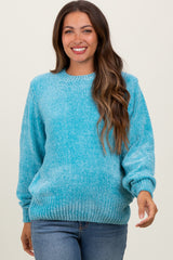 woman wearing a turquoise maternity sweater with long sleeves and a relaxed fit