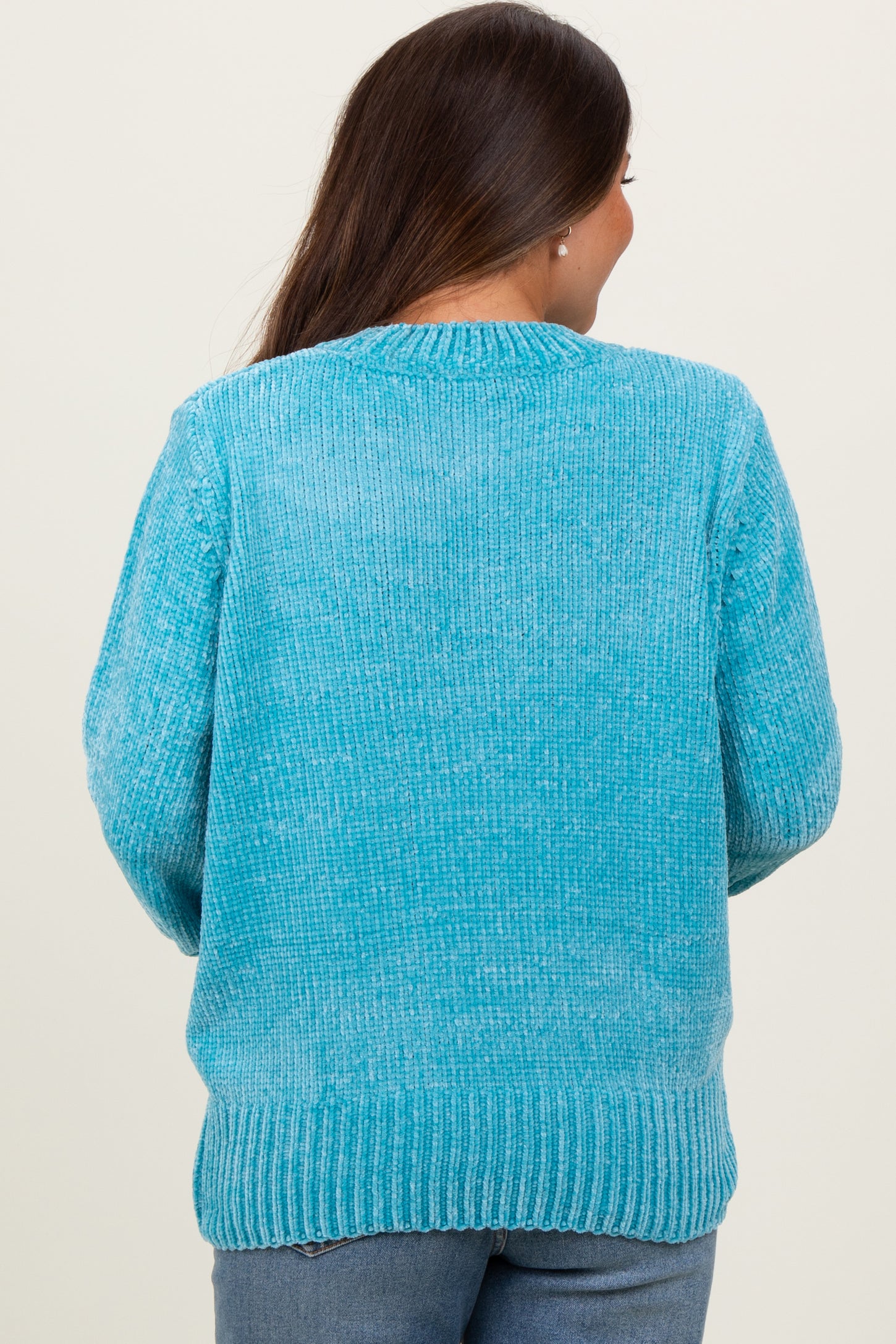 woman wearing a light blue maternity sweater with a relaxed fit and ribbed hem