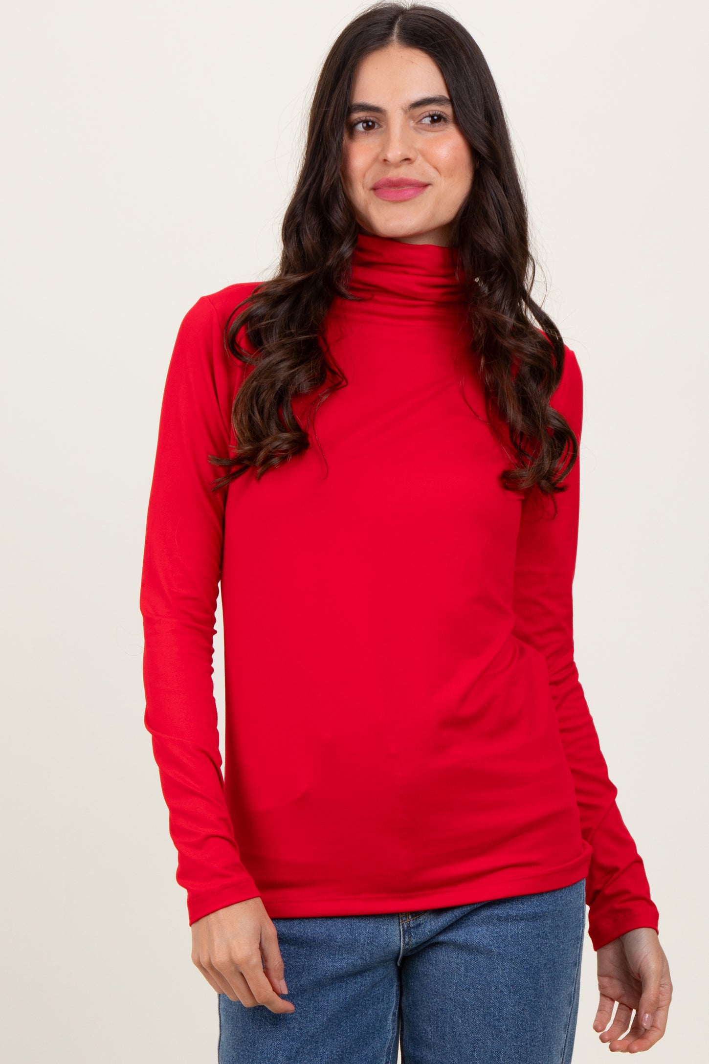 woman wearing a red long sleeve turtleneck top with fitted style and slight draping