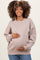woman wearing a taupe oversized sweatshirt, holding her baby bump, maternity wear, styled with blue jeans