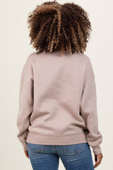woman wearing a light taupe maternity sweatshirt with a relaxed fit, shown from the back