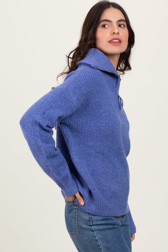 woman wearing a light purple knit pullover sweater with a folded collar and side pockets, paired with jeans