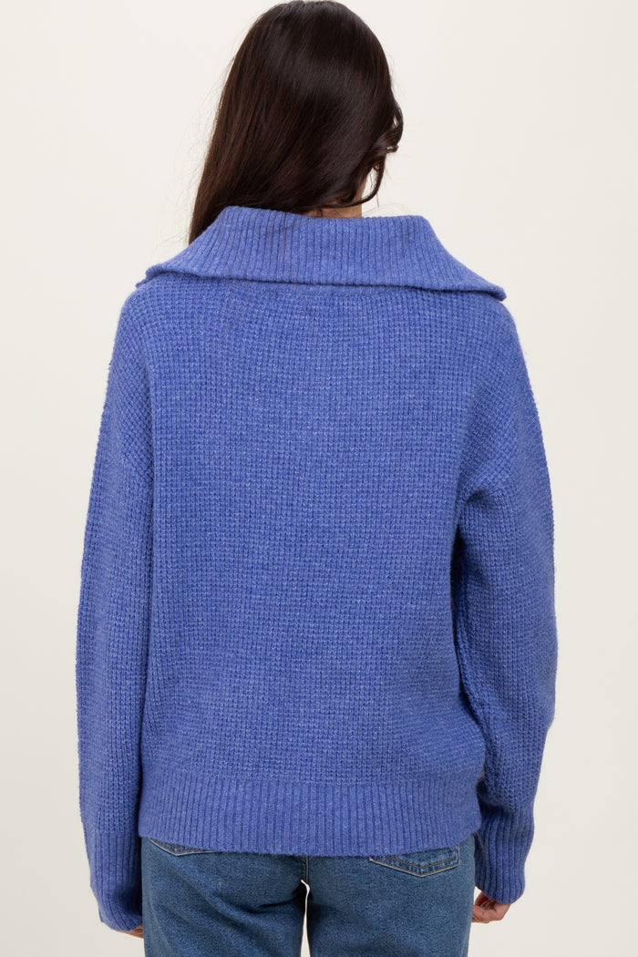 woman wearing a cozy blue sweater with a wide collar, seen from the back