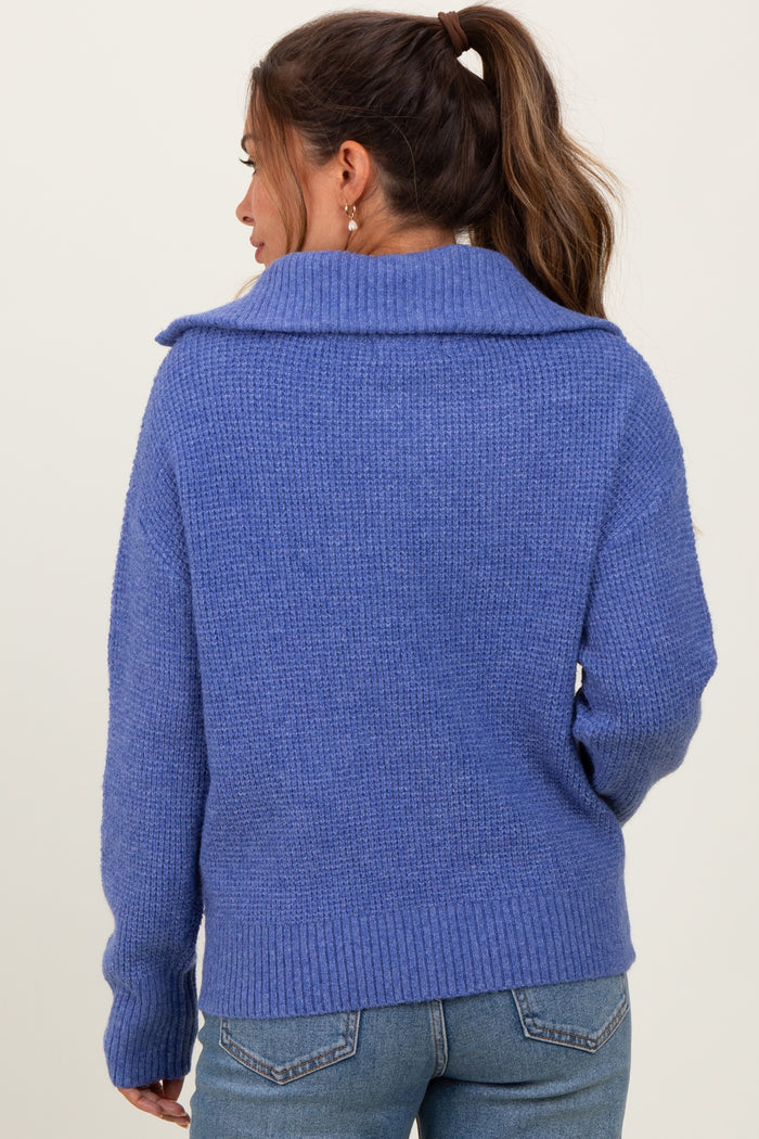 woman wearing a cozy blue maternity sweater with a wide collar and ribbed hem, showcasing a relaxed fit from the back