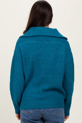 woman wearing a teal oversized sweater with a large collar, viewed from the back