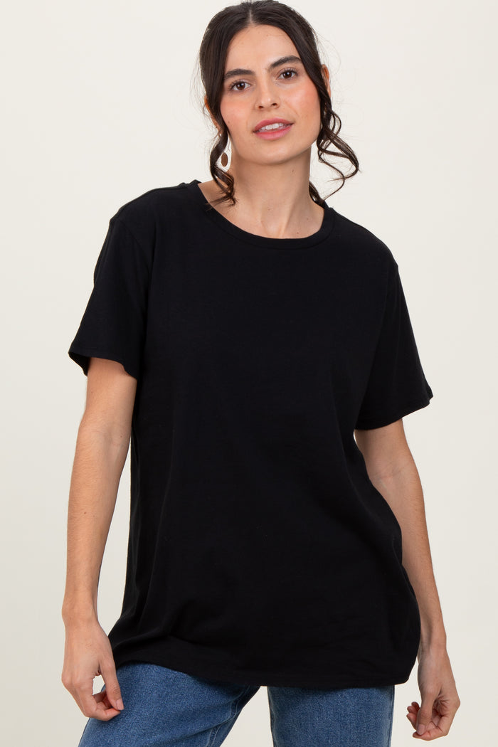 woman wearing a relaxed fit black t-shirt with short sleeves and a round neckline, paired with denim jeans
