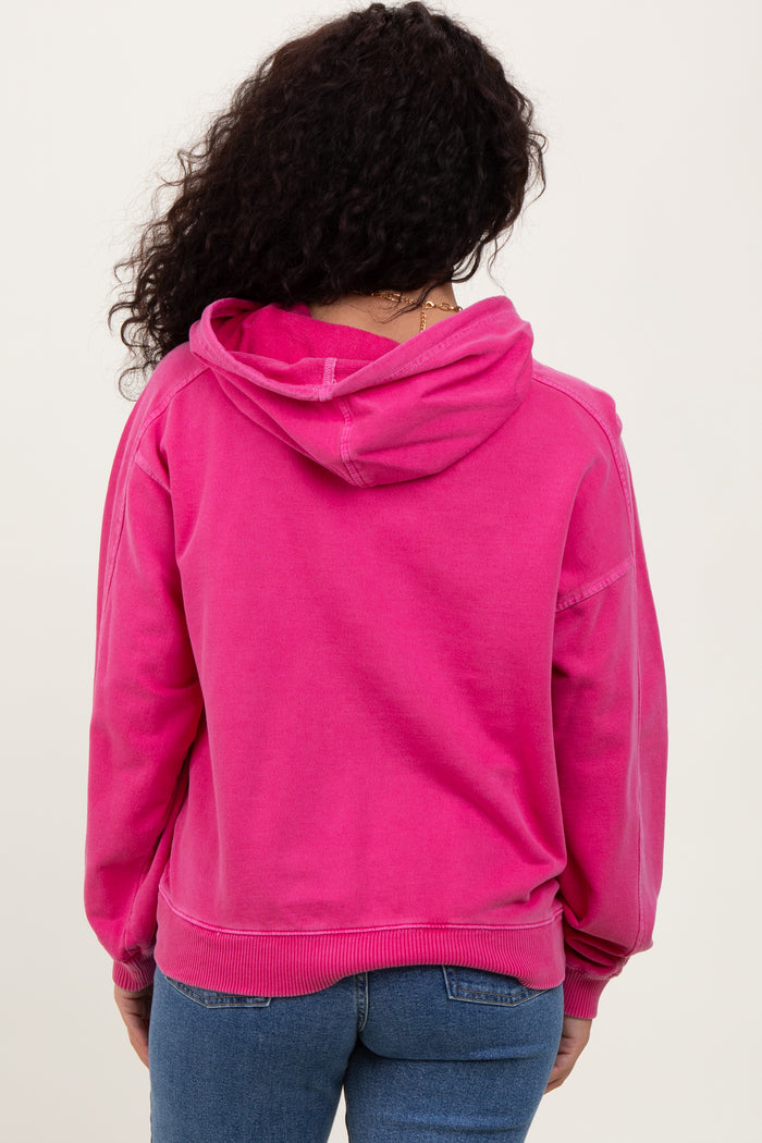 woman wearing a bright pink hoodie with a relaxed fit and a drawstring hood, viewed from the back