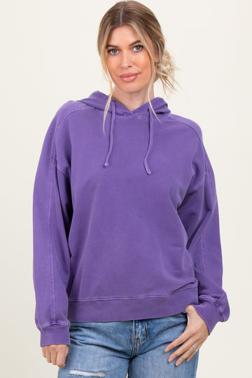 woman wearing a purple oversized hoodie with a drawstring and relaxed fit, paired with light blue jeans