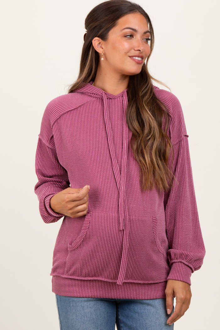 woman wearing a pink ribbed maternity hoodie with a drawstring and front pockets