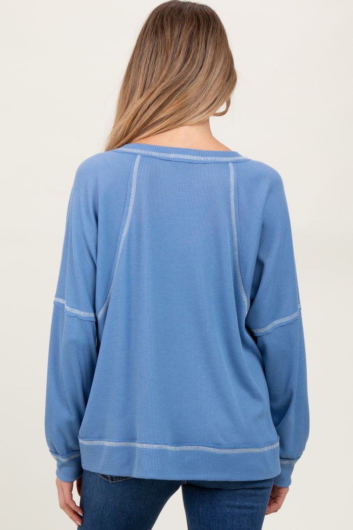 woman wearing a light blue maternity sweatshirt with a relaxed fit and long sleeves, viewed from the back