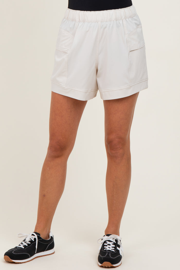 woman wearing white athletic shorts with an elastic waistband and front pockets