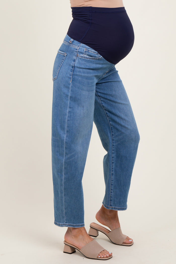 woman wearing a pair of light blue maternity jeans with a stretchy navy waistband and a visible baby bump