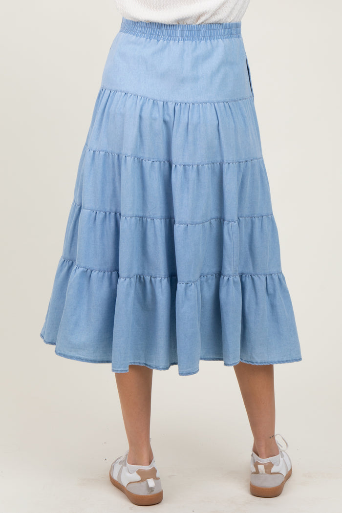 woman wearing a light blue tiered maternity skirt with an elastic waistband, viewed from the back