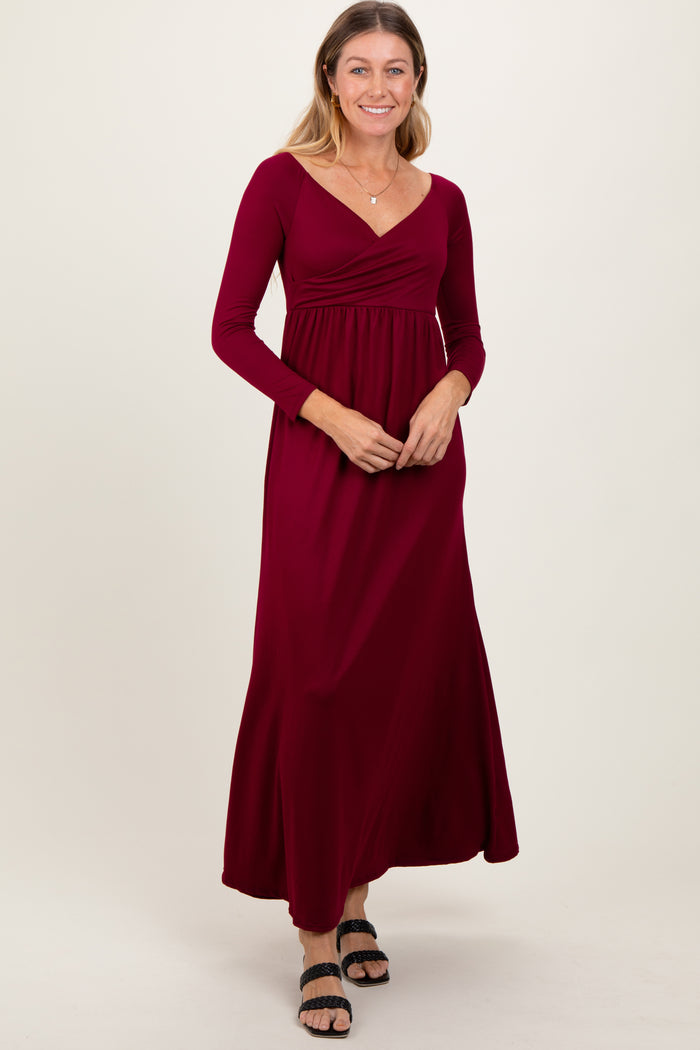 woman wearing a burgundy long sleeve maxi dress with a v-neck and gathered waist