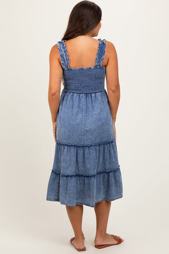 woman wearing a blue denim maternity dress with a smocked bodice and tiered skirt, showing her back