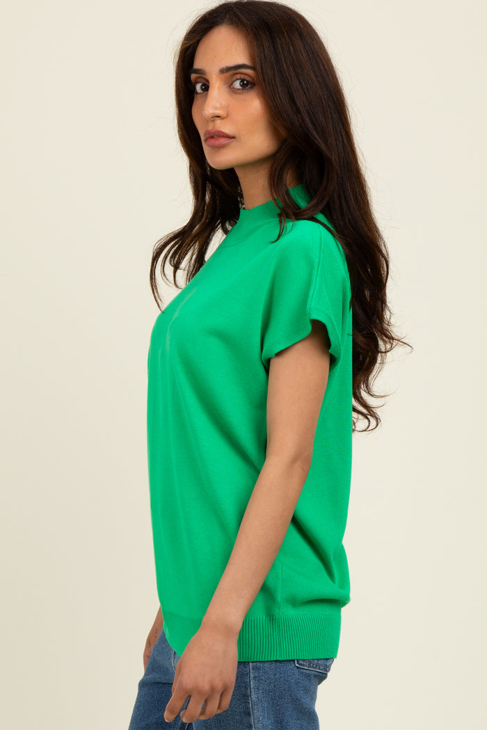 woman wearing a vibrant green short sleeve sweater with a relaxed fit and ribbed hem