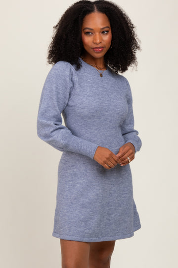woman wearing a light blue sweater dress with long puff sleeves and a relaxed fit