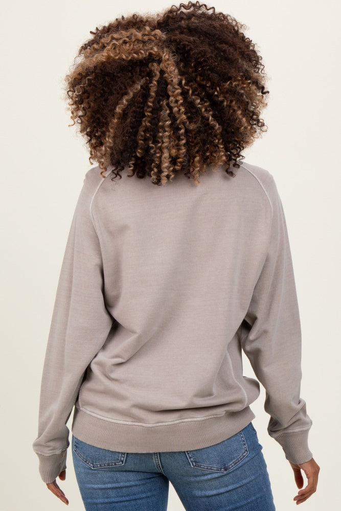 woman wearing a light gray maternity sweatshirt, seen from the back, paired with blue jeans