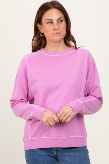 woman wearing a pink long sleeve sweatshirt with ribbed cuffs and hem, styled casually with blue jeans