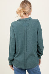 woman wearing a green ribbed long sleeve button-up shirt, seen from the back