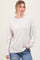 woman wearing a light pink oversized ribbed sweater with long sleeves and a relaxed fit
