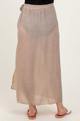 woman wearing a beige maternity maxi skirt with a tie detail at the waist and a flowing, lightweight design