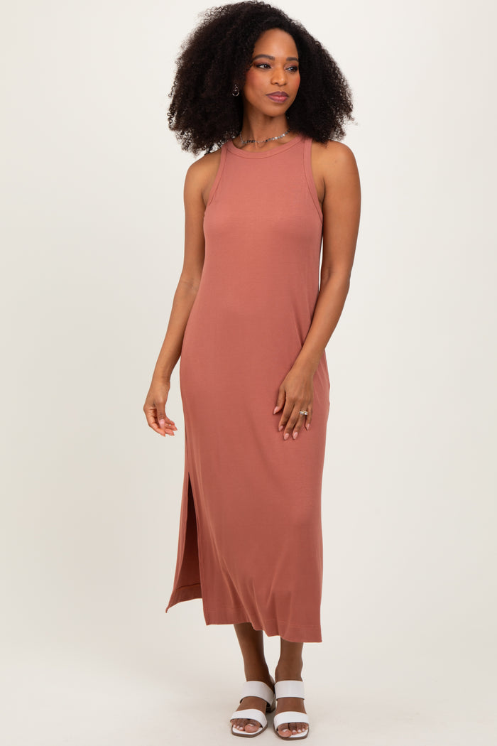 woman wearing a dusty rose sleeveless maxi dress with side slit and styled with white heeled sandals
