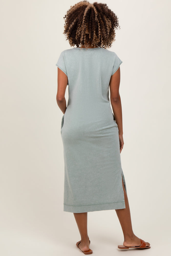 woman wearing a light green maternity maxi dress with short sleeves and side slits, shown from the back