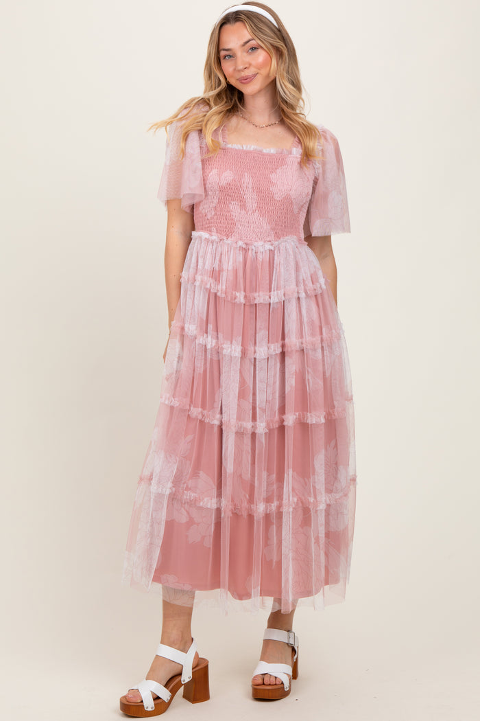 woman wearing a light pink tiered lace dress with short puff sleeves and a square neckline