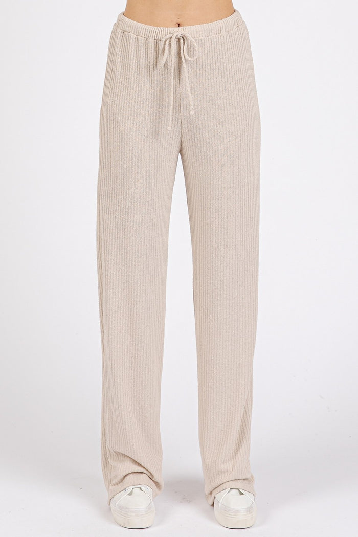 woman wearing beige ribbed lounge pants with an elastic drawstring waist