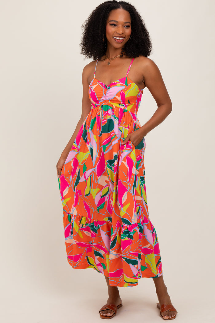 woman wearing a vibrant multicolored floral maxi dress with spaghetti straps and pockets