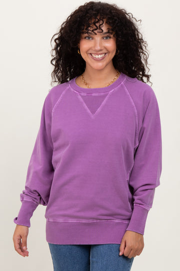 woman wearing a purple oversized sweatshirt with ribbed details and long sleeves