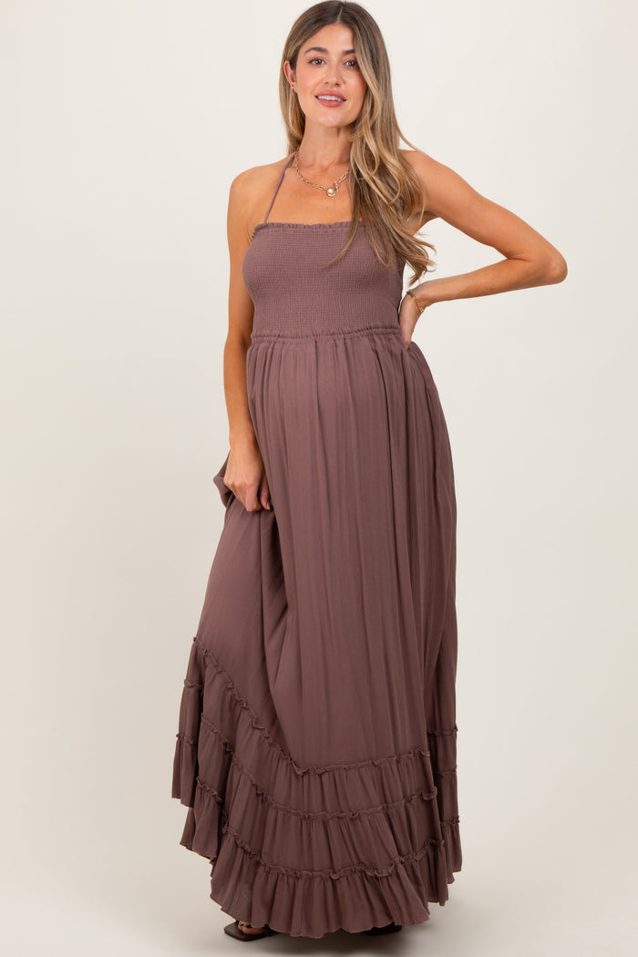 woman wearing a dusty mauve maternity maxi dress with a smocked bodice and tiered ruffle hem, showcasing her baby bump