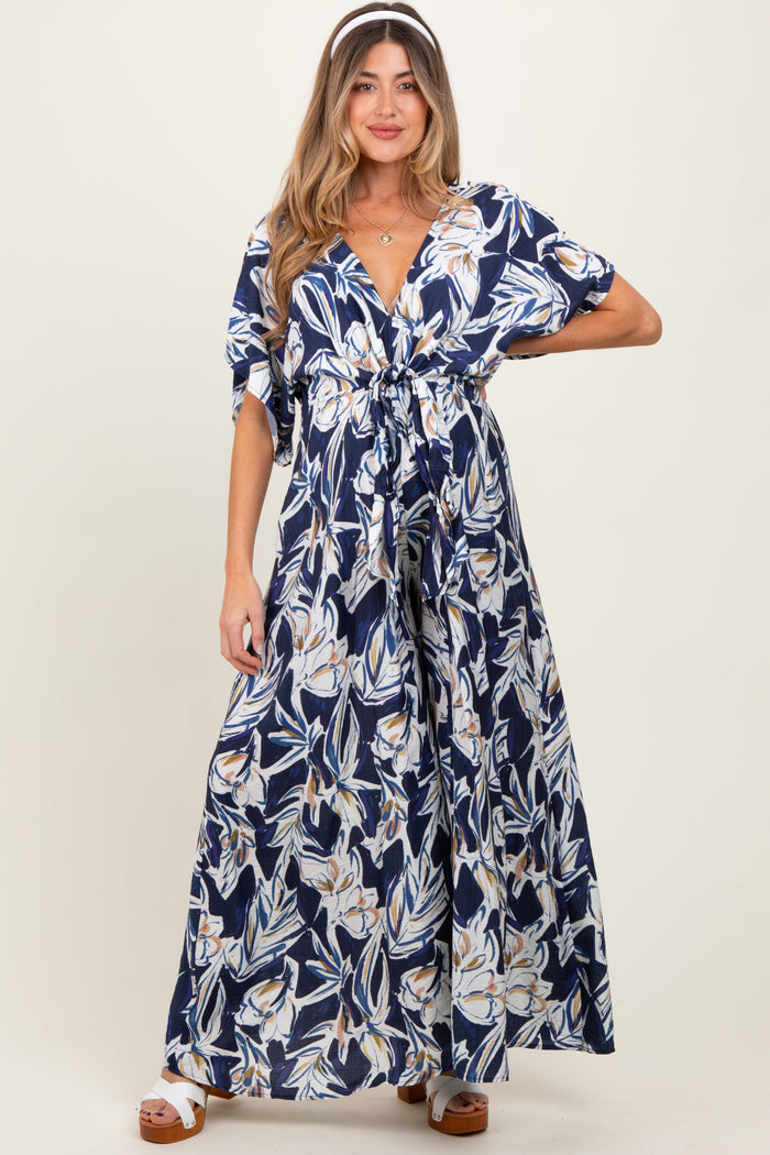 woman wearing a navy floral maxi maternity dress with a tie front and short sleeves, showing her baby bump