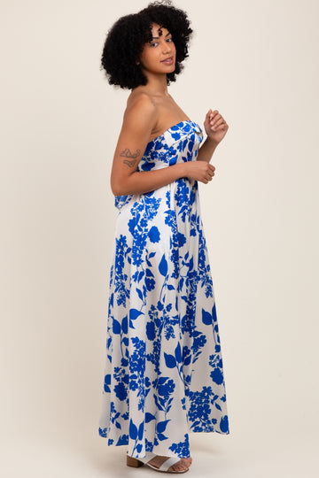 woman wearing a strapless maxi dress with blue floral print and a flowing silhouette