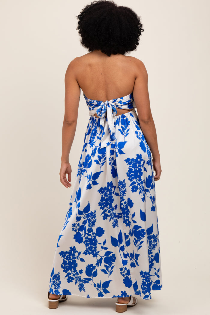 woman wearing a backless blue and white floral maxi dress with a tied bow detail at the back