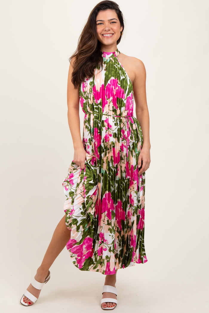 woman wearing a colorful floral maxi dress with a halter neck and flowing design, standing in a relaxed pose