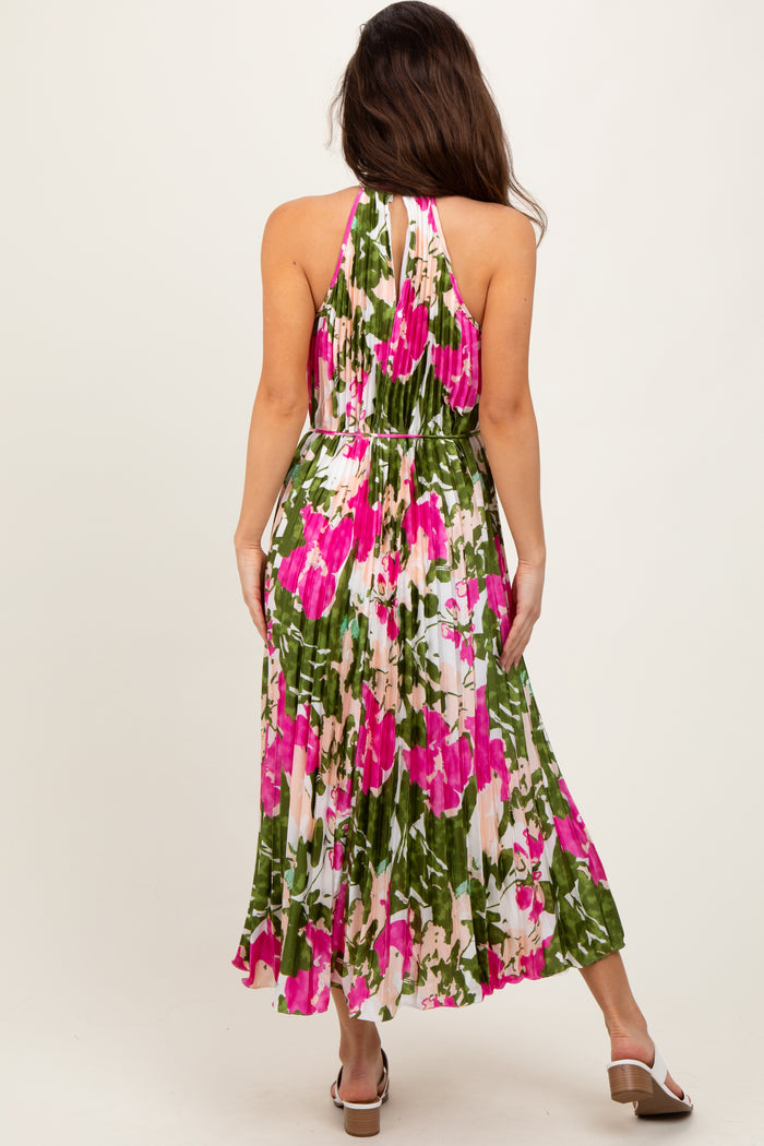 woman wearing a colorful floral maxi dress with halter neckline and pleated skirt, shown from the back