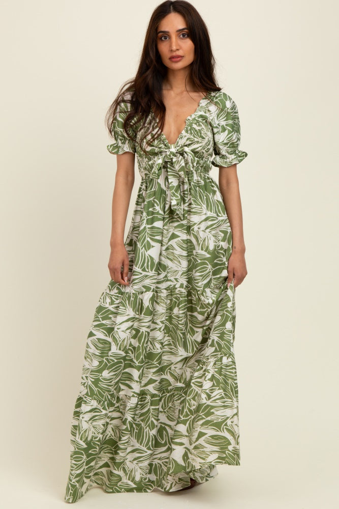 woman wearing a green floral maxi dress with puff sleeves and a tie front detail
