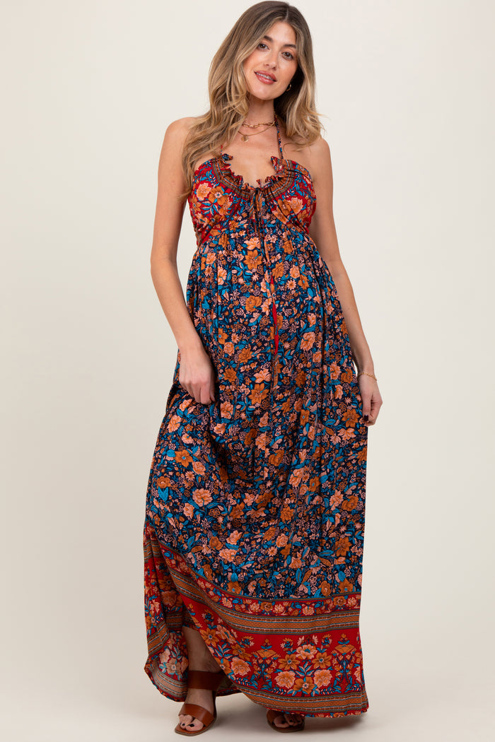 woman wearing a colorful floral print maternity maxi dress with adjustable straps and a flowing silhouette