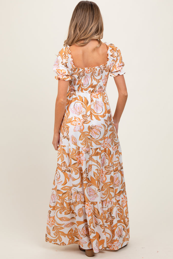 woman wearing a floral print maternity maxi dress with puff sleeves, seen from the back