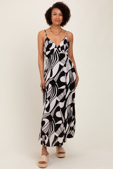 woman wearing a black and white patterned maxi dress with thin straps and a v-neckline