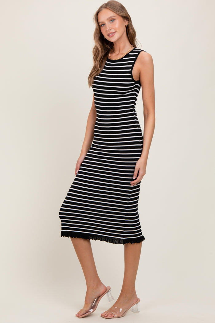 woman wearing a black and white striped sleeveless midi dress with a lace hem detail