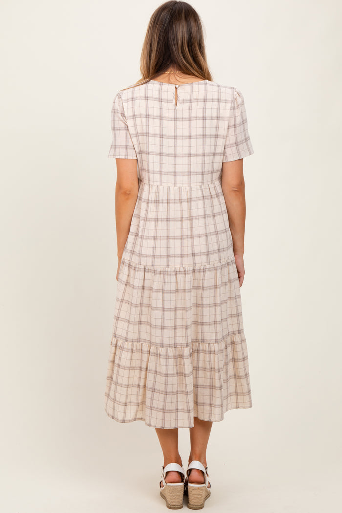 woman wearing a checkered tiered midi dress with short sleeves and a keyhole back detail