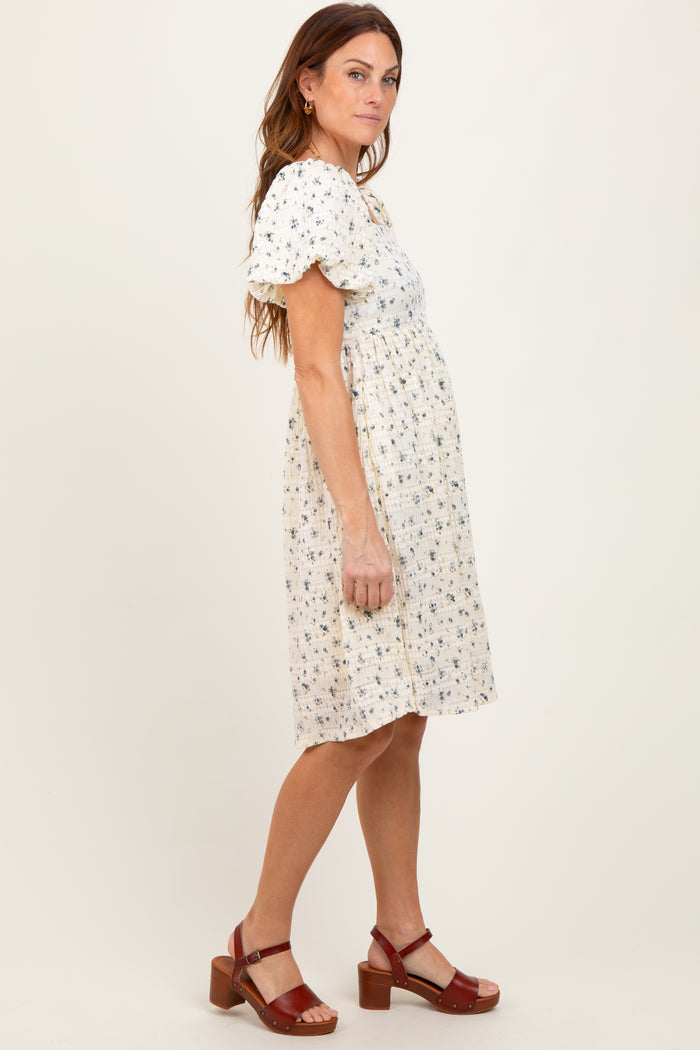 woman wearing a floral print short sleeve dress with a gathered waist and brown heeled sandals