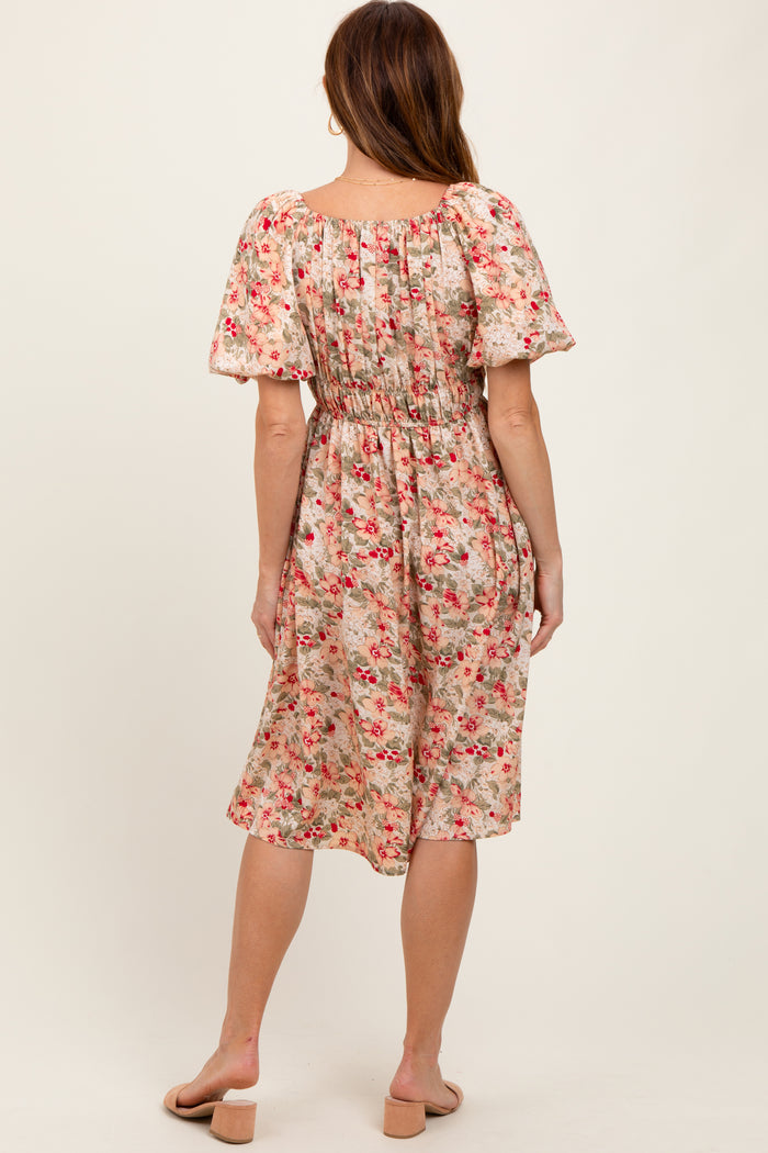 woman wearing a back view of a flowy floral midi dress with puff sleeves and an elasticated waist